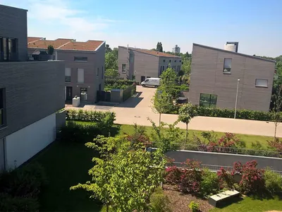 Stadthäuser mit Holzfassade und begrünten Dächern, davor ein Garten. Düsseldorf-Heerdt, Am Ökotop (Großansicht)