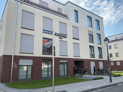Wohnhaus mit Klinkersockel und hellem Putz an einer Straßenecke. Düsseldorf, Wangeroogestraße (Großansicht)