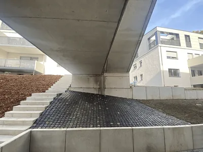 Treppe unter einem auskragenden Gebäudeteil, dahinter Wohnhäuser. Hattingen, Isenbergstraße (Großansicht)
