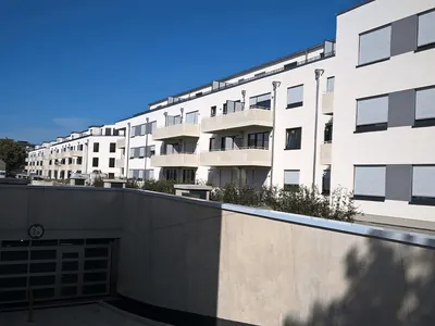 Langgestreckte Wohnanlage mit Balkonen über einer Tiefgarageneinfahrt. Köln-Weiden, Ignystraße (Großansicht)